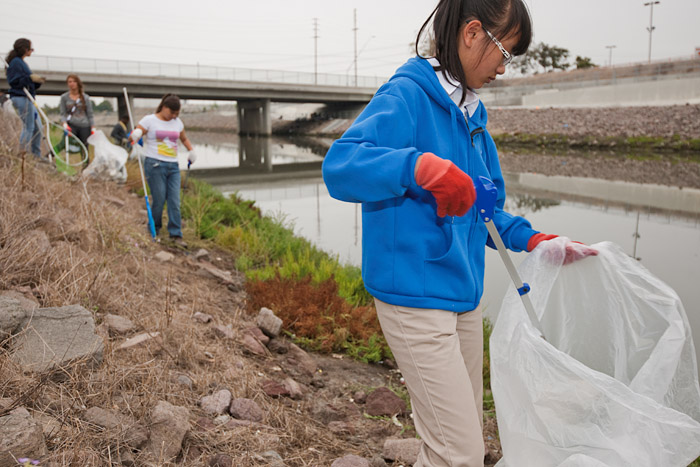 Serra High School students remove trash from the bank of the channel.