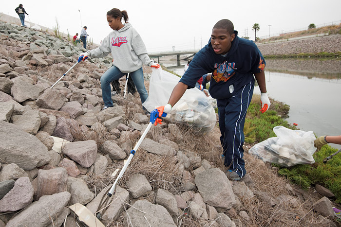 Serra High School students remove trash from the bank of the channel.