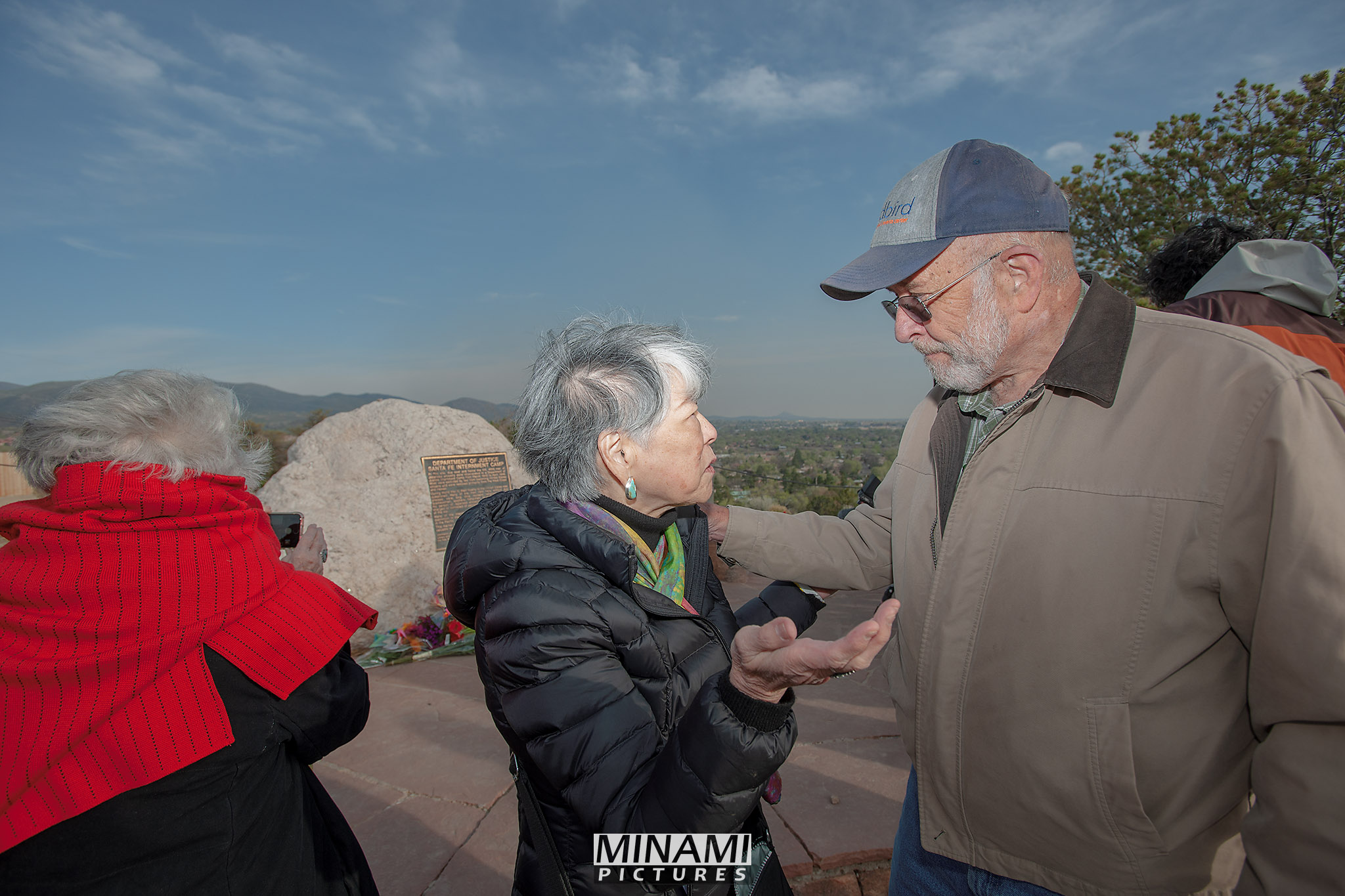 Gail Okawa, professor and historian, speaks with David Mason, who as a three year old Santa Fean during World War II, threw cacti at Japanese prisoners.